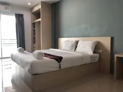 a bedroom with a large bed with white sheets and pillows at Khao Oat airport in Nai Yang Beach