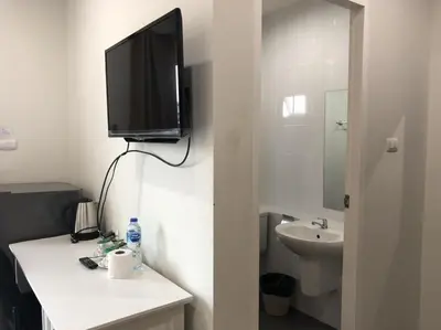 a bathroom with a sink and a tv on the wall at Khao Oat airport in Nai Yang Beach