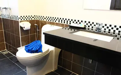 a bathroom with a toilet and a sink with a blue towel at 88 Hotel in Patong Beach