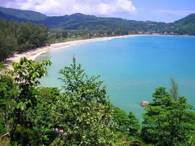 a view of a beach with trees in the foreground at 88 Hotel in Patong Beach