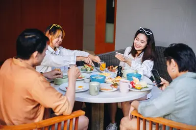 a group of people sitting around a table eating food at Holiday Inn Express Phuket Patong Beach Central by IHG in Patong Beach