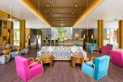a living room with a couch and tables and chairs at Holiday Inn Express Phuket Patong Beach Central by IHG in Patong Beach