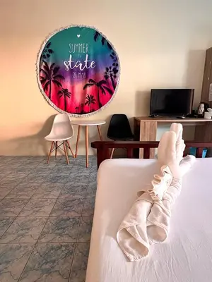 a person laying on a bed with their foot in a room at Baankasemsuk Resort \u822c\u5494 \u6df1\u5bbf in Patong Beach
