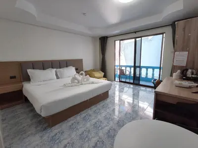 a hotel room with a bed and a large window at Baankasemsuk Resort \u822c\u5494 \u6df1\u5bbf in Patong Beach