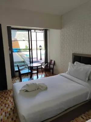 a bedroom with a large white bed and a table at Baankasemsuk Resort \u822c\u5494 \u6df1\u5bbf in Patong Beach
