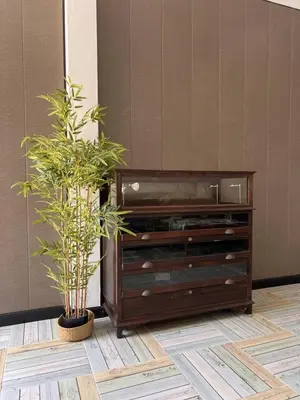 a wooden entertainment center with two potted plants at Baankasemsuk Resort \u822c\u5494 \u6df1\u5bbf in Patong Beach