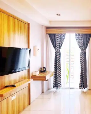 a room with a flat screen tv and a window at Cat Story Hotel in Patong Beach
