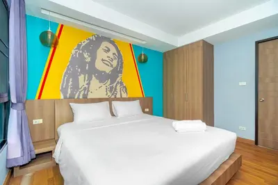 a bedroom with a bed with a painting on the wall at Anchan Boutique Hotel in Chalong