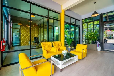 a lobby with yellow chairs and a table at Anchan Boutique Hotel in Chalong