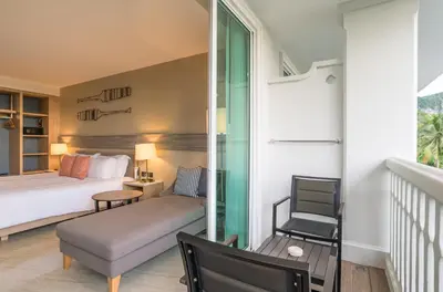 a bedroom with a bed and a chair at Centara Ao Nang Beach Resort & Spa Krabi in Ao Nang Beach
