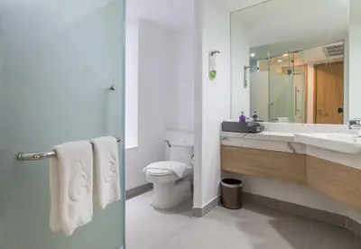 a bathroom with a toilet and a sink and a mirror at Centara Ao Nang Beach Resort & Spa Krabi in Ao Nang Beach
