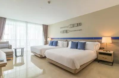 a hotel room with two beds and a couch at Centara Ao Nang Beach Resort & Spa Krabi in Ao Nang Beach