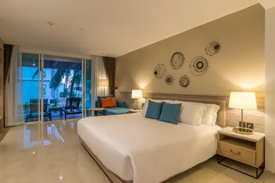 a bedroom with a large bed and a living room at Centara Ao Nang Beach Resort & Spa Krabi in Ao Nang Beach