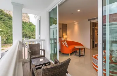 a room with a balcony with a couch and chairs at Centara Ao Nang Beach Resort & Spa Krabi in Ao Nang Beach