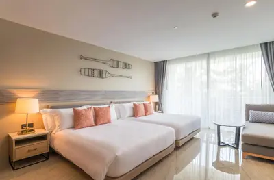a hotel room with two beds and a couch at Centara Ao Nang Beach Resort & Spa Krabi in Ao Nang Beach