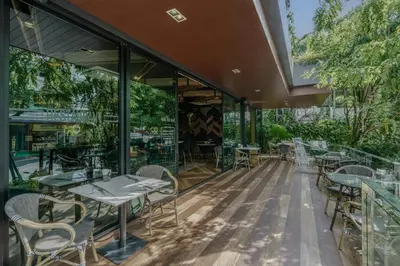 an outdoor dining area with tables and chairs at Rak Elegant Hotel Patong in Patong Beach