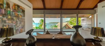 a living room with a couch and a large window at Surin Beach Oceanfront Villa with Ocean and Beach views in Surin Beach