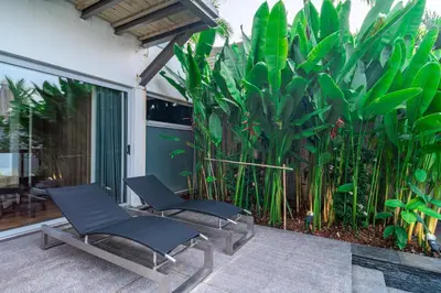 two chairs sitting on a patio with plants at Surin Beach Oceanfront Villa with Ocean and Beach views in Surin Beach