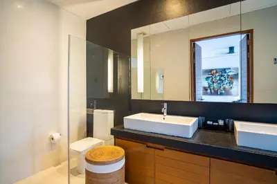 a bathroom with a sink and a mirror and a toilet at Surin Beach Oceanfront Villa with Ocean and Beach views in Surin Beach