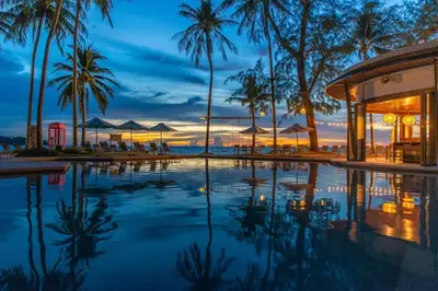 a swimming pool with palm trees and a resort at SAii Laguna Phuket in Bang Tao Beach