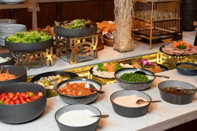 a buffet with bowls of food on a table at SAii Laguna Phuket in Bang Tao Beach