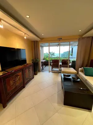 a living room with a large television and a couch at Luxury Apartment Kata Beach The Accenta in Kata Beach