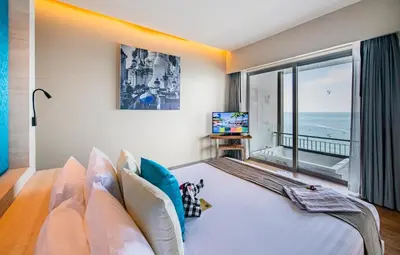 a bedroom with a large bed with a view of the ocean at Cape Sienna Phuket Gourmet Hotel & Villas - SHA Extra Plus in Kamala Beach