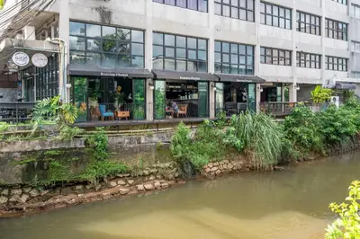 a building with a restaurant next to a river at Quip Bed & Breakfast in Phuket Town