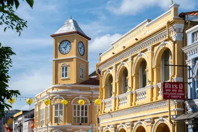 a yellow building with a clock tower on it at Quip Bed & Breakfast in Phuket Town