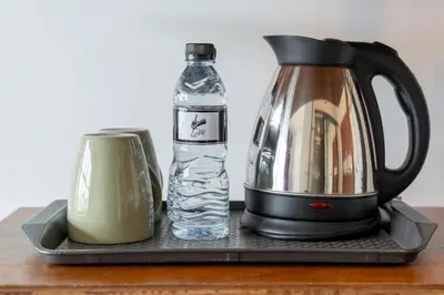 a coffee maker and a bottle of water on a table at Quip Bed & Breakfast in Phuket Town