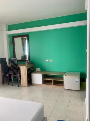 a room with a green wall with a desk and chairs at Kata Guesthouse Tuscany in Kata Beach