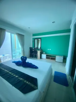 a bedroom with a bed with a teddy bear on it at Kata Guesthouse Tuscany in Kata Beach
