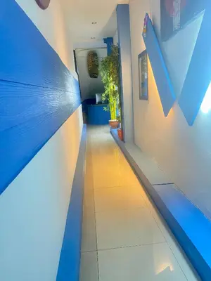a hallway with a blue and white wall at Kata Guesthouse Tuscany in Kata Beach