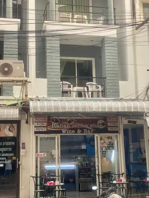 a restaurant with tables and chairs on a balcony at Kata Guesthouse Tuscany in Kata Beach