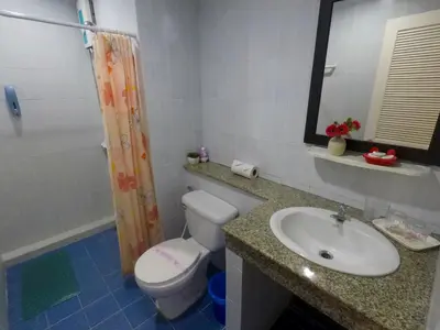 a bathroom with a sink and a toilet and a mirror at Kata Guesthouse Tuscany in Kata Beach