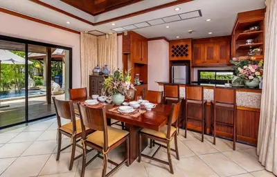 a dining room with a wooden table and chairs at VILLA TOGIAN Private Pool Naiharn beach in Rawai Beach