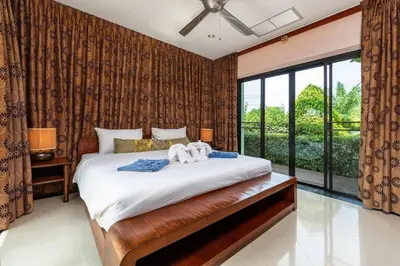 a bedroom with a large bed and a large window at VILLA TOGIAN Private Pool Naiharn beach in Rawai Beach