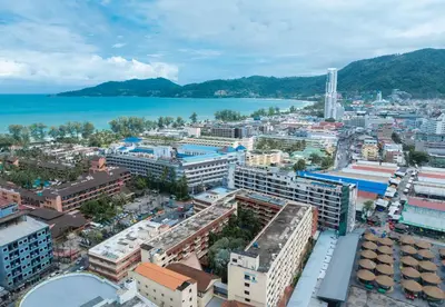 an aerial view of a city with a body of water at Baumanburi Hotel Patong in Patong Beach