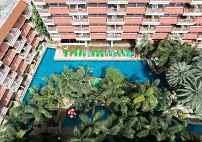 an aerial view of a hotel with a pool and palm trees at Baumanburi Hotel Patong in Patong Beach