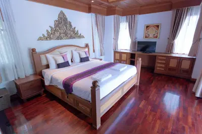 a bedroom with a bed and a desk and a television at Lawootrip Villa in Patong Beach