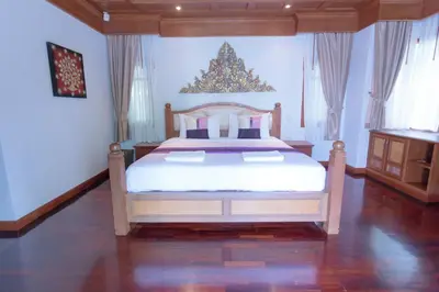 a bedroom with a bed and a christmas tree on the wall at Lawootrip Villa in Patong Beach