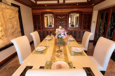 a dining room with a long table with flowers on it at Lawootrip Villa in Patong Beach