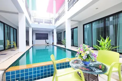 a pool in a building with a table and chairs at Tina Boutique Resort in Thalang