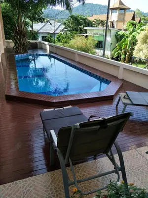 a swimming pool on a balcony with a chair next to it at Thalassa in Nai Harn Beach
