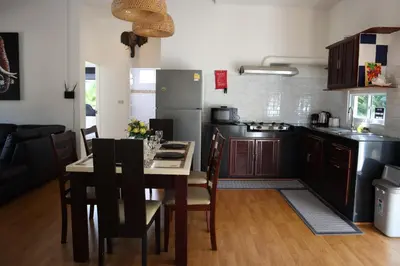 a kitchen with a table with chairs and a refrigerator at Relax private Pool Villas - 4 bedroom villas in Ao Nang Beach