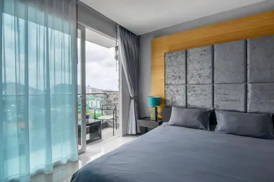 a bedroom with a large bed and a large window at Emerald Terrace Resort in Patong Beach