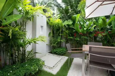a garden with trees and plants in a building at Trichada Tropical in Bang Tao Beach