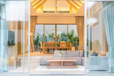 a living room with a couch and a table at Trichada Tropical in Bang Tao Beach