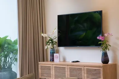 a flat screen tv sitting on top of a entertainment center at Trichada Tropical in Bang Tao Beach