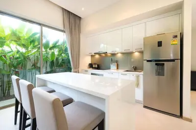 a kitchen with a white counter and a refrigerator at Trichada Tropical in Bang Tao Beach